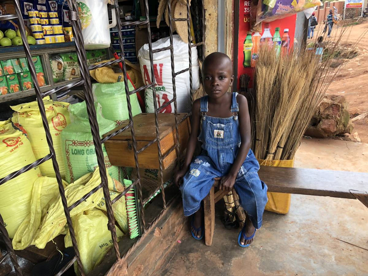 Junge vor Mini Markt in Kazo Uganda